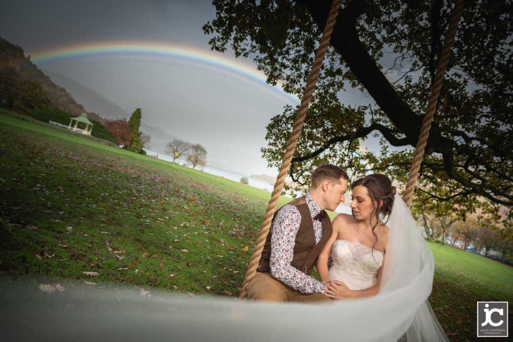 Bride and Groom on the rope swing with a rainbow